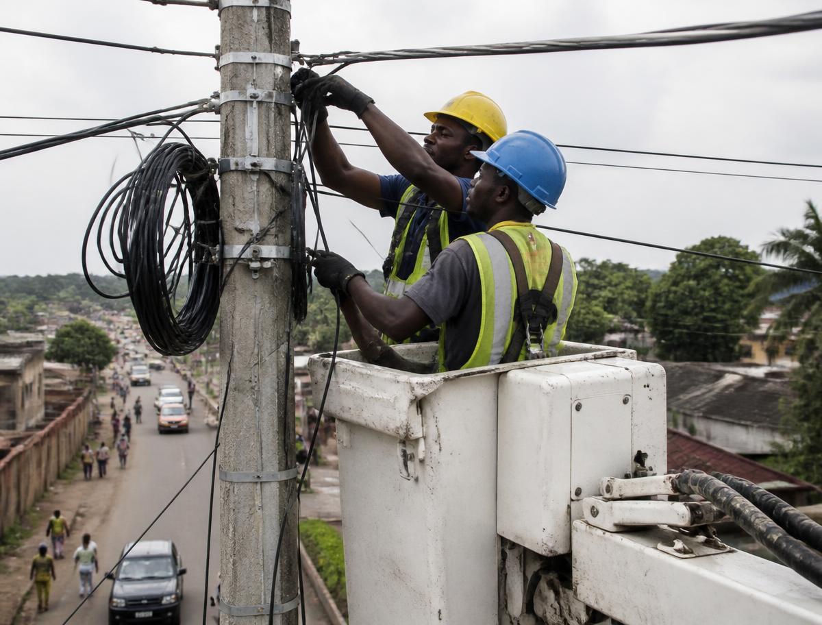 Techniciens CDS installant de la fibre optique aérienne sur un poteau